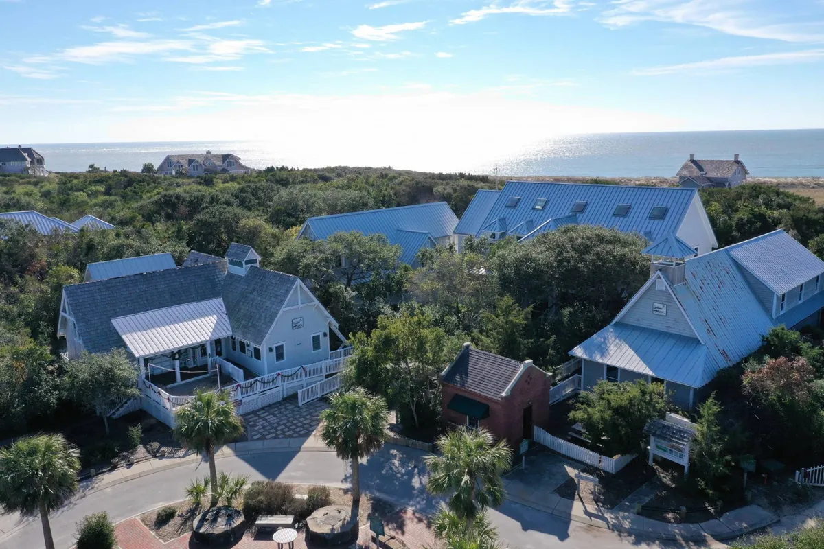 A peaceful garden scene with ocean views, surrounding greenery, and a scenic pathway leading from the homes toward the beach and nature trails. The atmosphere is tranquil, capturing opportunities for barbecues, relaxation, and nature walks right from the doorstep.